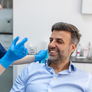 Smiling dental assistant showing patient clear aligner