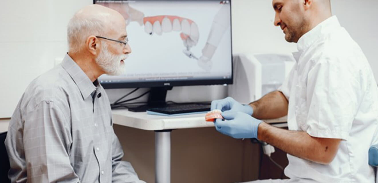 a dentist explaining to a patient how all-on-4 implants work